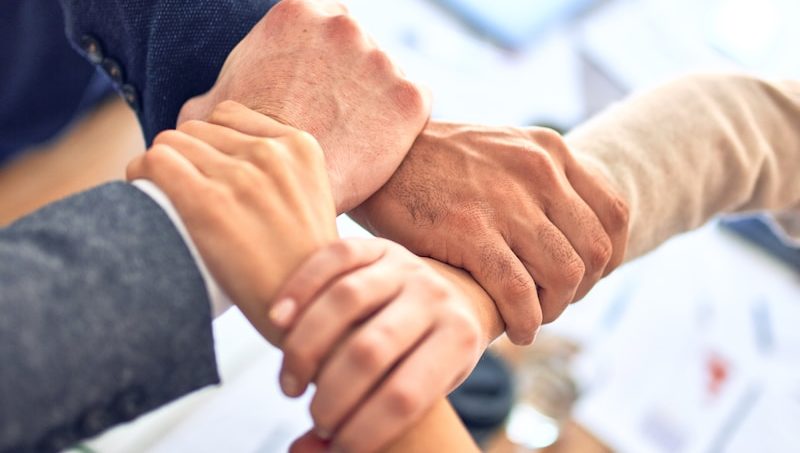 person in black long sleeve shirt holding persons hand